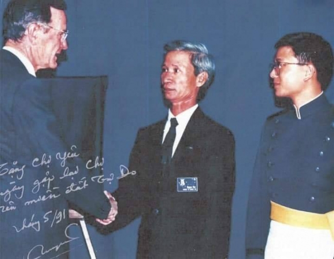 Bùi Quyền bắt tay Tổng Thống George H. W. Bush trong lễ ra trường của con trai Bùi Quang (bên phải)